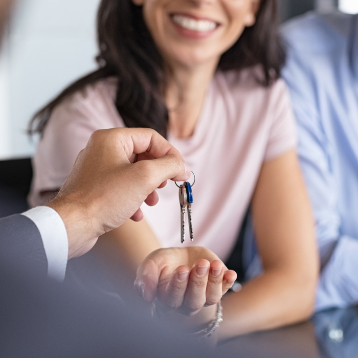 Real estate agent giving house keys to woman